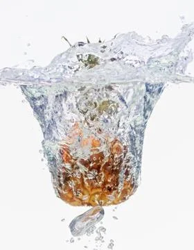 Small pineapple falling in water on white Foto stock