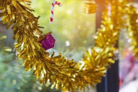 A Small pink artificial gift box with golden ribbon hanging on window. Stylis Stock Photos