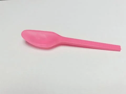 Small Pink Plastic Spoon on White Background Stock Photos