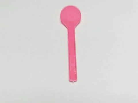 Small Pink Plastic Spoon on White Background Stock Photos