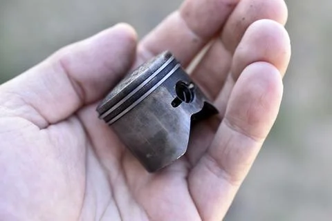A small piston in the hand from an internal combustion engine Stock Photos