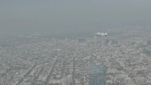 A small plane Cessna is flying over city, raw colors Stock Footage 119349664