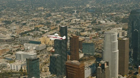 A small plane Cessna is flying over city Stock Footage 119349719