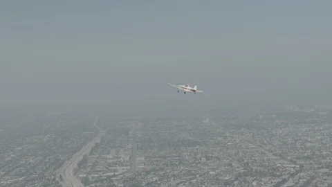 A small plane Cessna is flying over city, raw colors Stock Footage 119349877