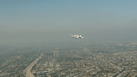 A small plane Cessna is flying over city Stock Footage 119349886