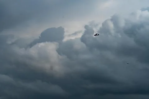 Small plane in cloudy sky for rainmaking. White fluffy clouds with small airc Foto stock
