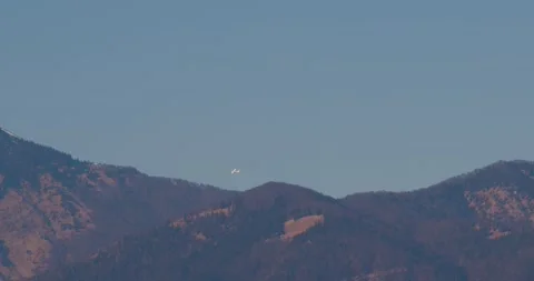 A small plane flies in front of the mighty and snow-covered mountains Stock Footage 220520381