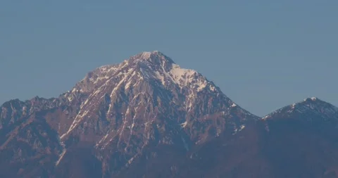 A small plane flies in front of the mighty and snow-covered mountains Stock Footage 220523022