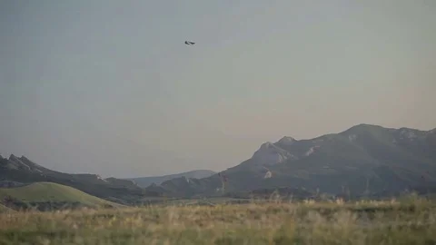 A small plane flies over a ridge Stock Footage 76461823