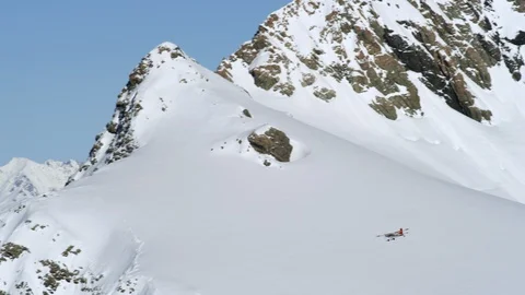 Small plane flying above snow covered mountains Stock Footage 116749440