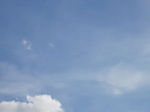 Small plane flying in blue cloudy sky Stock Footage 342339781