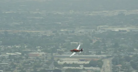 Small plane flying over suburbs, overcast, helicopter, drone footage Video stock 106368863