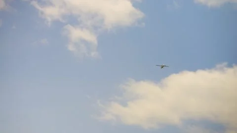 Small plane flying through clouds on a warm sunny and cloudy day Stock Footage 242057496