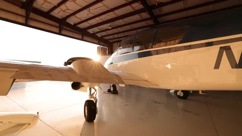 Small Plane Parked In Hangar With Sunlight Lens Flare 스톡 동영상 147006084