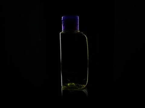 Small plastic bottle on black background Stock Photos