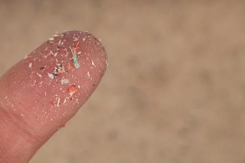 Small Plastic pellets on finger. Micro plastic, problem. Stock Photos