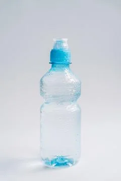 Small plastic water bottle on bright minimal background, hydration concept Foto stock