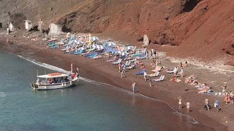 Small pleasure boat swimming to full of people beach offering sightseeing tours Stock Footage
