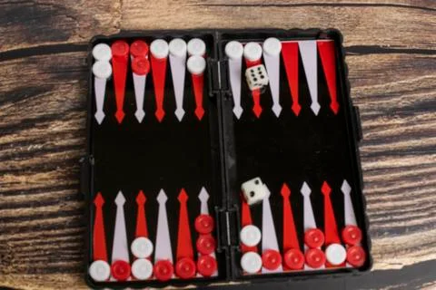 Small pocket backgammon on a wooden table Stock Photos