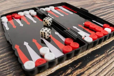 Small pocket backgammon on a wooden table Stock Photos