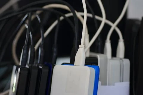 Small portable hard drives in stack connected to rear PC backup digital compu Stock Photos