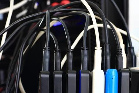 Small portable hard drives in stack connected to rear PC backup digital compu Stock Photos