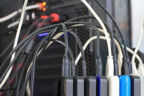 Small portable hard drives in stack connected to rear PC backup digital compu Stock Photos