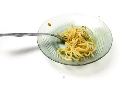 A small portion of cooked spaghetti with sauce served on a clear glass plat.. Stock Photos