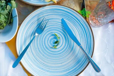 A small portion of a small lettuce leaf on a white plate with a knife and fork Stock Photos