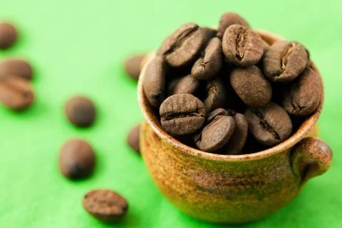 Small pot of coffee beans on the green matter 스톡 사진