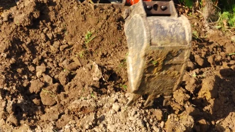 A small power shovel scooping soil. Stock Footage 95591920