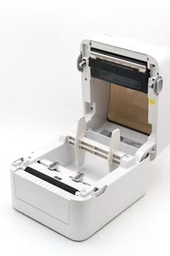 Small printer sits open on a white surface with paper inside Stock Photos