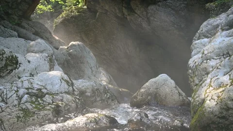 Small pristine Alpine creek flowing between rock boulders under old bridge Stock Footage 137154954