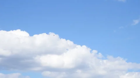 A small private plane flies in the clouds against the blue sky. Stock Footage 154552087