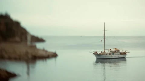 A small private sailing yacht returns to the bay from sailing. Tilt-shift. Stock Footage 233441949