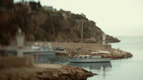 A small private sailing yacht returns to the bay from sailing. Tilt-shift. Stock Footage 235520084