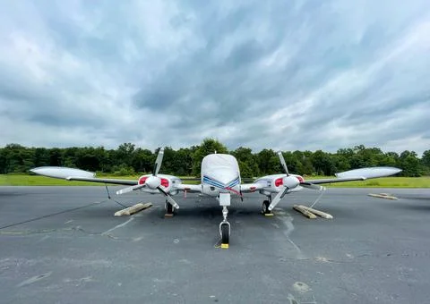 Small private two propeller plane resting on tarmac. Stock Photos