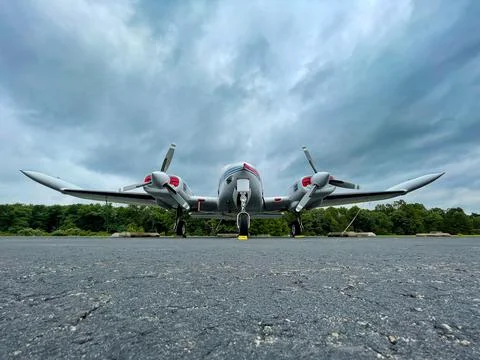 Small private two propeller plane parked on tarmac. Stock Photos