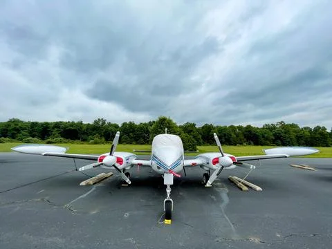 Small private two propeller plane resting on tarmac. Stock Photos