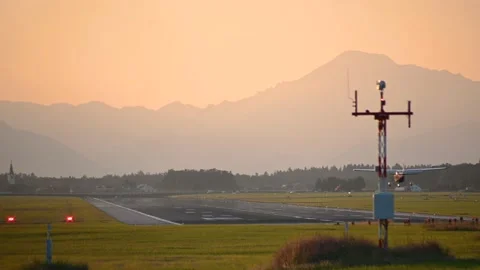 Small private ultralight plane landing against orange sky Stock Footage 162245151