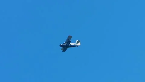 A small propeller plane flies in a clear sky Stock Footage 278873804