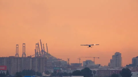 Small Propeller Plane Taking Off at Sunset Over City Stock Footage 335017897