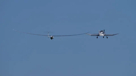Small propeller plane towing a modern high performance glider on take off Stock Footage 167881415