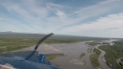 Small propeller-powered bush airplane flying above a river in Alaska. Vidéo 127064818
