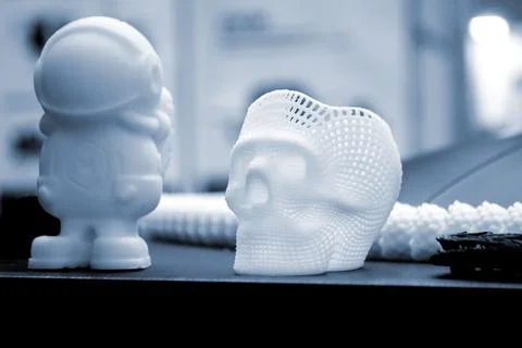 Small prototype human skull toy 3D printed molten white plastic surface close-up Stock Photos
