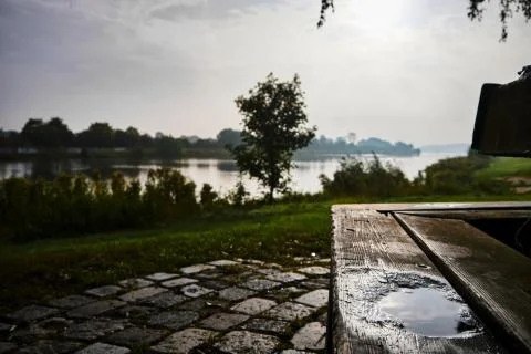Small puddle on a bench overlooking a lake on a sunny day in winter Stock Photos