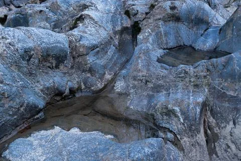 Small puddle in blue rock close up Stock Photos