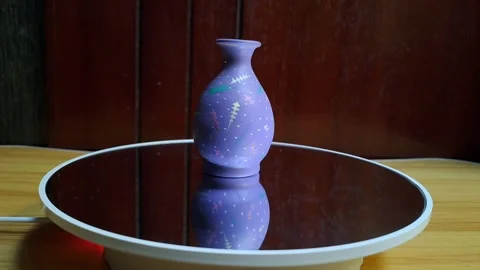 A small purple ceramic vase featuring colorful circular patterns Stock Footage 341309177
