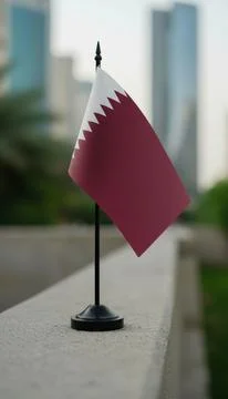 Small Qatari Flag on Black Stand in City Setting Stock Photos