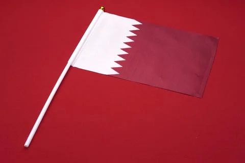 Small Qatari flag isolated on a red background. Foto stock